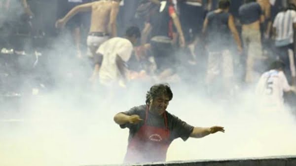 Los hinchas de Gimnasia en retirada de la tribuna escapando de los gases de la Policía. Foto: diario El Sol.