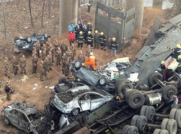 Rescuers look for survivors near a wreckage of vehicles after a expressway bridge partially collapsed on the Lianhuo highway in Mianchi county