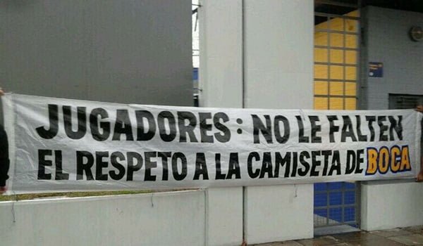 Dos persoanas sostienen el trapo de la misiva a los jugadores de Boca, en una imagen subida a Twitter este sábado. 