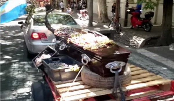 Empresarios de la vid del Este provincial, marginados del planeamiento del negocio, pasearon un cajón de muertos con uvas en la tapa por el centro de Mendoza.  Foto: Captura TV