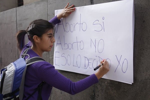 14 de mayo 2014/ Santiago Una activista del Movimiento de Mujeres de Chile pega un cártel a favor del aborto en las afueras del Ministerio de Salud, durante una manifestación de activistas por la legalización del aborto. La manifestación surgió a raíz del caso de una adolescente internada en urgencia en el Hospital Luis Tisné después de un aborto clandestino.  FOTO: DAVID VON BLOHN/ AgenciaUNO