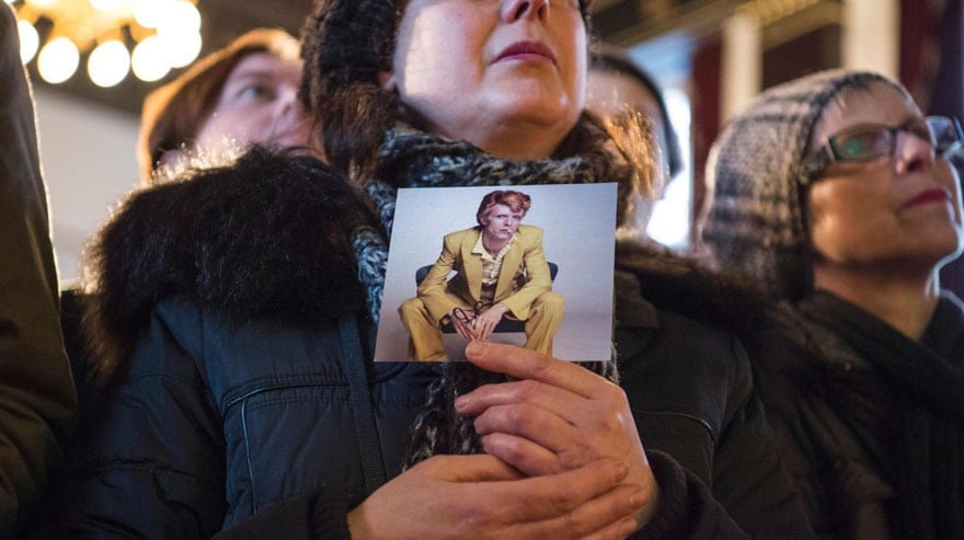 A fan of British pop star David Bowie holds a photo of Bowie as she attends memorial event for Bowie in the main hall of Berlin's Hansa recording studio on January 15, 2016. David Bowie, who died of cancer on January 10, 2016, recorded at the studio in the 70s and 80s. / AFP / John MACDOUGALL